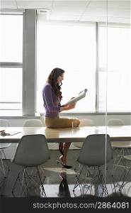 Business woman sitting on conference table side view