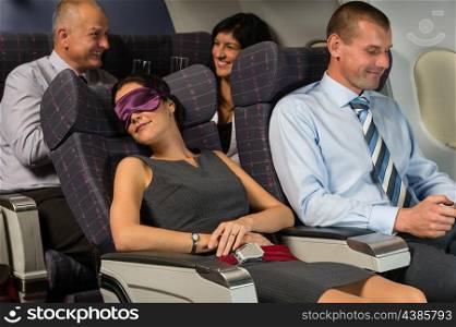 Business woman sleep during night flight airplane cabin passengers