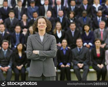 Business woman standing in front of business people sitting in bleachers, portrait