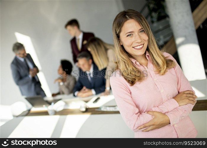 Business woman standing with her staff have a meeting in the background