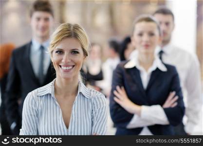 business woman standing with her staff in background at modern bright office conference room