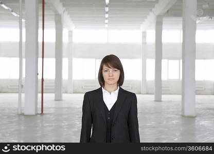 Business woman stands in empty warehouse