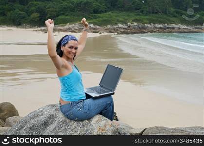 Business woman successfull with laptop computer on the beach