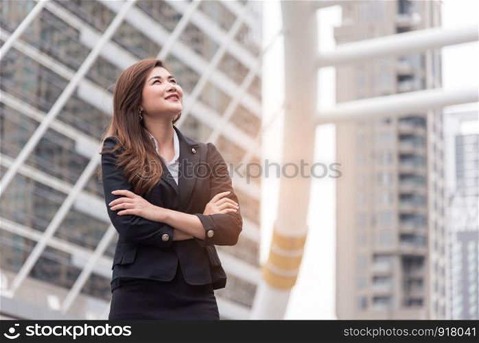 Business woman thinking and look up for succeed in project. Happy life and Business successful concept. Urban and outdoor