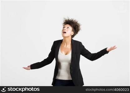 Business woman trying to catch something falling from the sky, isolated over a gray brackground