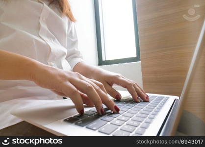 Business woman typing on laptop selected focus on right hand in business technology concept