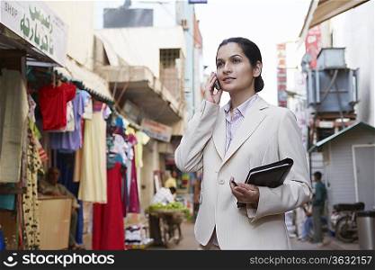 Business woman using cell phone on bazaar