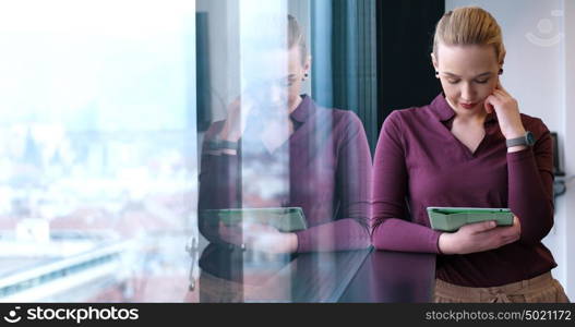 Business Woman Using Digital Tablet in corporate office by window