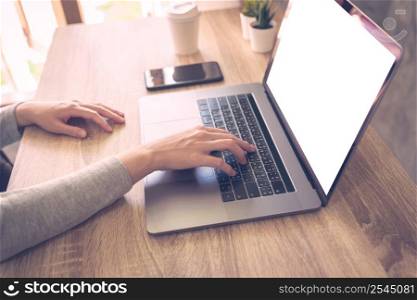 Business woman using laptop computer do online activity on wood table at home office.