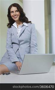 Business woman using laptop indoors