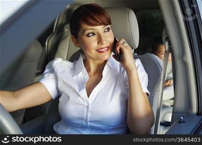 Business woman using mobile phone with son in car