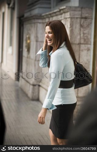 Business woman walking away from businessmen, outdoors