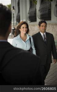 Business woman walking with businessman, outdoors