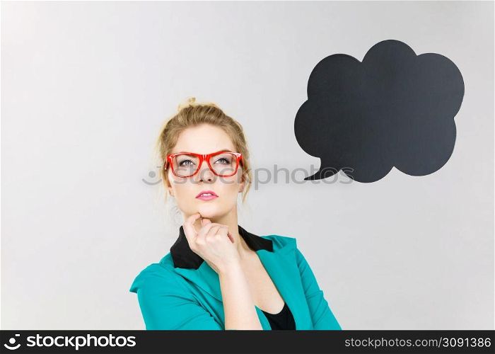 Business woman wearing blue jacket and eyeglasses intensive thinking finding great problem solution, black thinking or speech bubble next to her.. Business woman intensive thinking