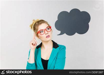 Business woman wearing blue jacket and eyeglasses intensive thinking finding great problem solution, black thinking or speech bubble next to her.. Business woman intensive thinking