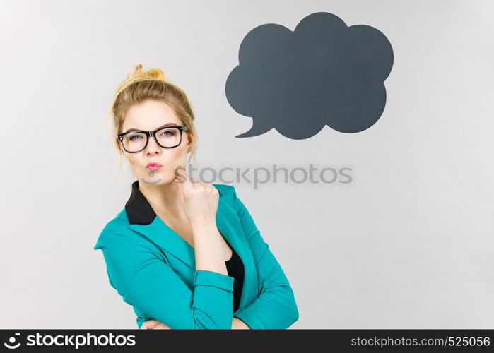 Business woman wearing blue jacket and eyeglasses intensive thinking finding great problem solution, black thinking or speech bubble next to her.. Business woman intensive thinking