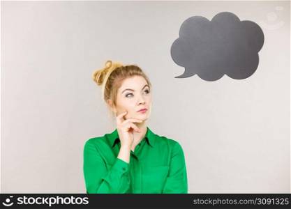Business woman wearing green jacket and eyeglasses intensive thinking finding great problem solution, black thinking or speech bubble next to her.. Business woman intensive thinking