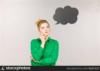 Business woman wearing green jacket and eyeglasses intensive thinking finding great problem solution, black thinking or speech bubble next to her.. Business woman intensive thinking