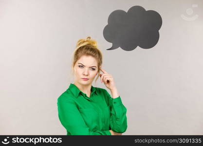 Business woman wearing green jacket and eyeglasses intensive thinking finding great problem solution, black thinking or speech bubble next to her.. Business woman intensive thinking