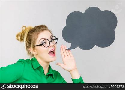 Business woman wearing green shirt and eyeglasses yelling telling something someone, black thinking or speech bubble next to her.. Business woman yelling telling something
