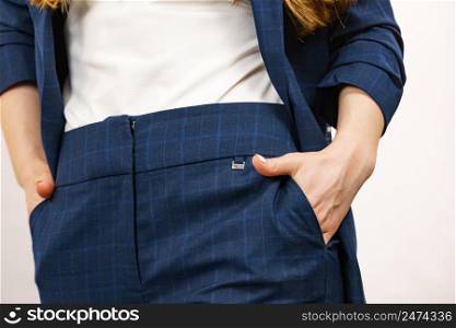 Business woman wearing suit holding hand in pants pocket. Detail view hips in trousers. Business woman in suit