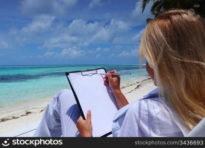 business woman with blank paper lying on a chaise lounge in the tropical ocean coast