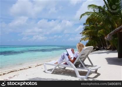 business woman with blank paper lying on a chaise lounge in the tropical ocean coast