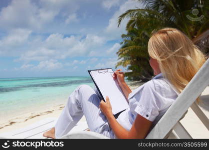 business woman with blank paper lying on a chaise lounge in the tropical ocean coast