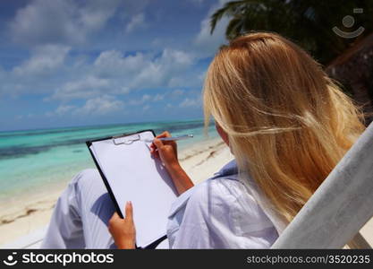 business woman with blank paper lying on a chaise lounge in the tropical ocean coast