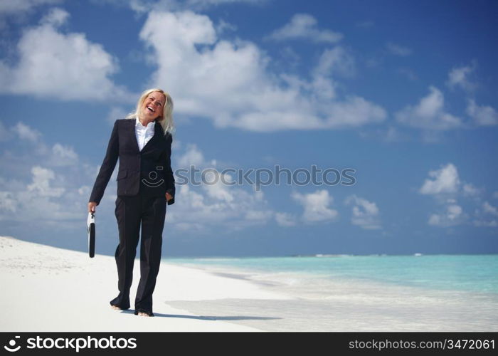 business woman with briefcase walking on the desolate ocean coast