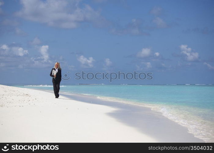 business woman with briefcase walking on the desolate ocean coast