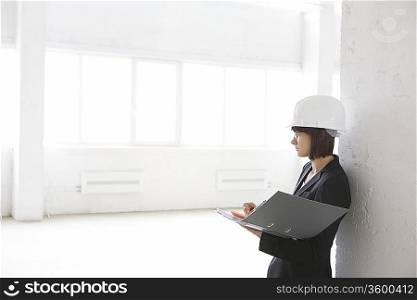 Business woman with file in empty warehouse