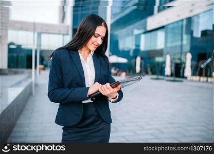 Business woman with laptop. Modern building, financial center, cityscape. Female businessperson in suit. Business woman with laptop outdoor