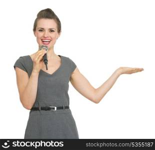 Business woman with microphone presenting something on empty hand