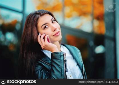 Business woman with smartphone close up near office building. Girl have conversation with cell phone. Beautiful caucasian young woman talking with mobile device. Business woman with smartphone close up near office building. Girl have conversation with cell phone. Beautiful caucasian young woman talking with mobile device.