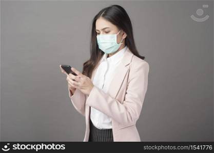 Business woman with surgical mask is using cell phone