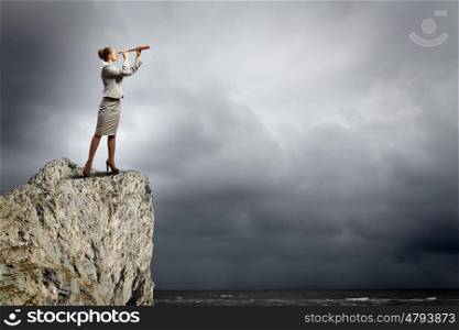 Business woman with telescope. Image of businesswoman looking in telescope standing atop of rock