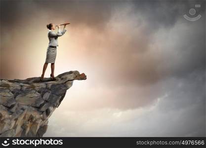 Business woman with telescope. Image of businesswoman looking in telescope standing atop of rock