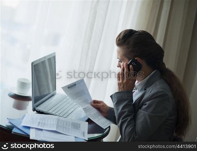 Business woman working and speaking mobile at hotel room