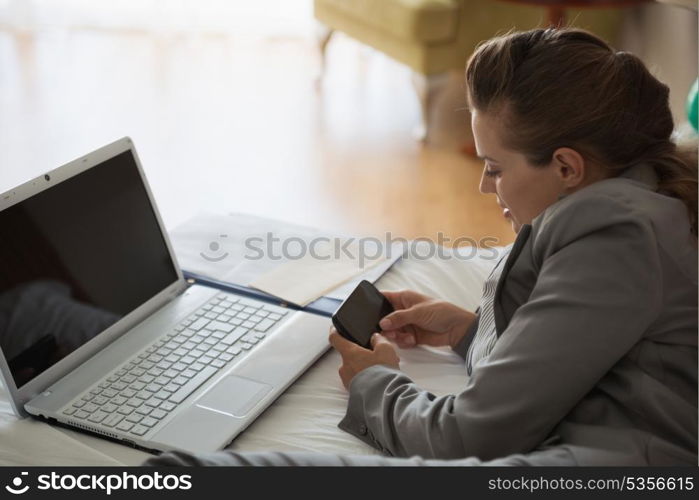 Business woman working on bed in hotel room