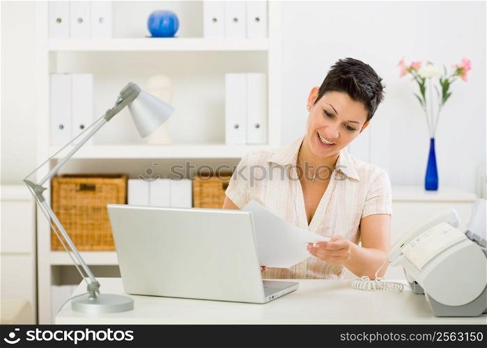 Business woman working on laptop computer at home.