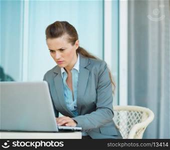 Business woman working on laptop on hotel terrace