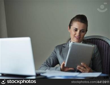 Business woman working with tablet PC in hotel room