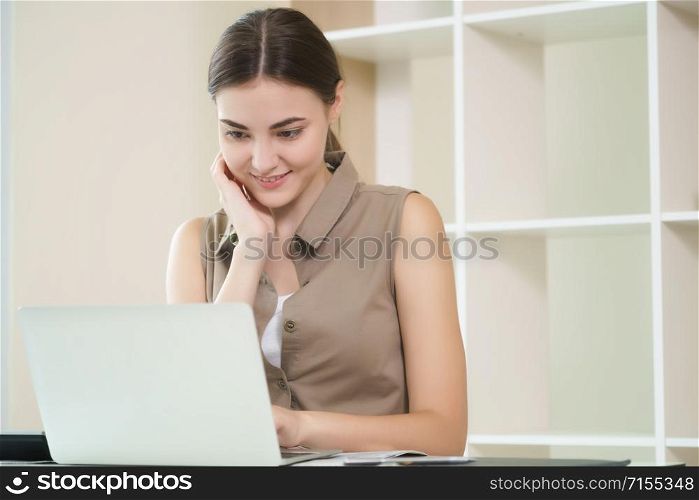 Business woman works on laptop computer in cozy home office while having concentration and thinking about her business. Small business and home office concept.