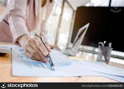 Business women analysis investment perform data document and calculating a valuation number