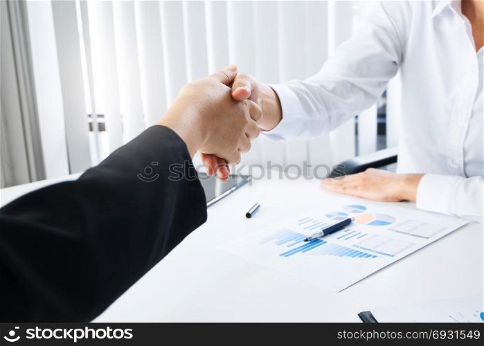 business women hands shaking at meeting room
