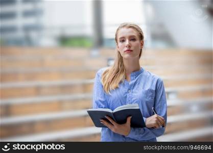 business women holding note look at camera while standing outdoor