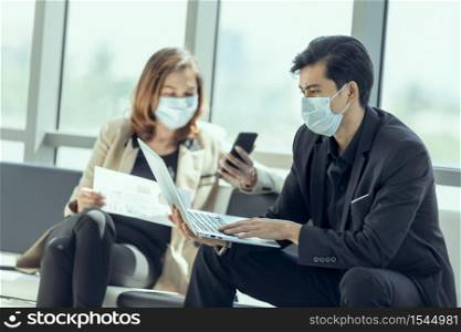 Business workers discussing something and wearing medical face mask for social distancing in new normal situation for virus prevention.