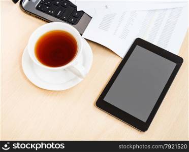 business workflow - above view cup of tea and tablet pc on office table