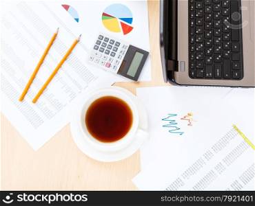 business workflow - cup of tea on table with tools in modern office